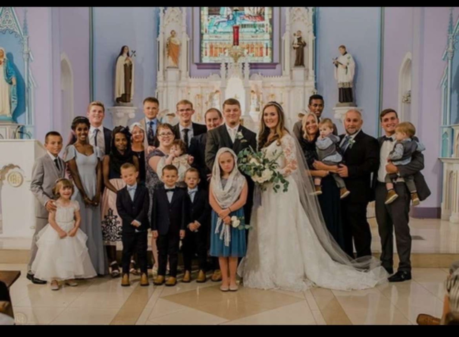 The Michalak family gathered together in church on a wedding day